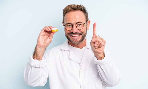 Bel homme d'âge moyen souriant et regardant amical montrant le concept de lentille de contact numéro un