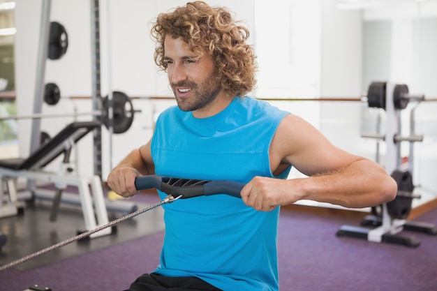 Bel homme à l&#39;aide de la bande de résistance dans la salle de gym