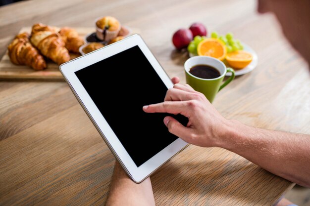 Bel homme à l&#39;aide de tablette dans la cuisine