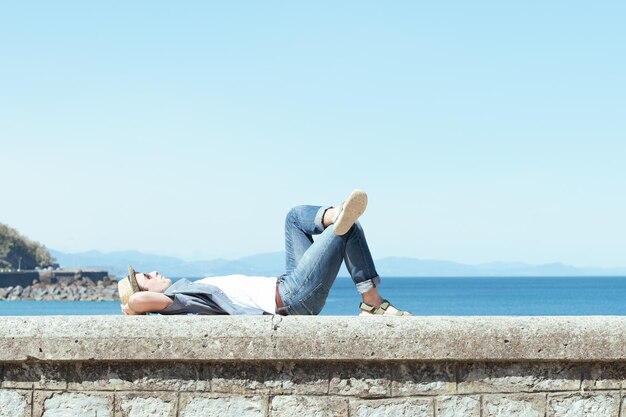 Bel homme allongé et relaxant dans une journée ensoleillée. Bain de soleil dans le concept d'été.