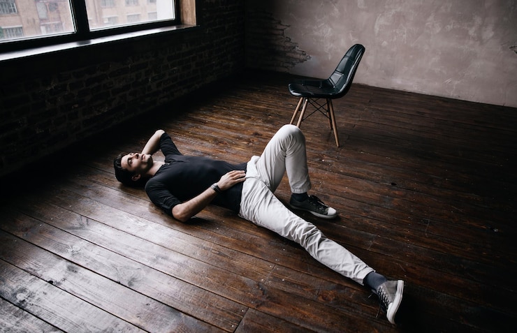 Photo un bel homme allongé sur le sol en bois dur dans un studio de cinéma.