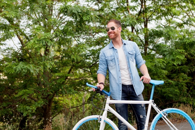 Bel homme appréciant son vélo dans le parc