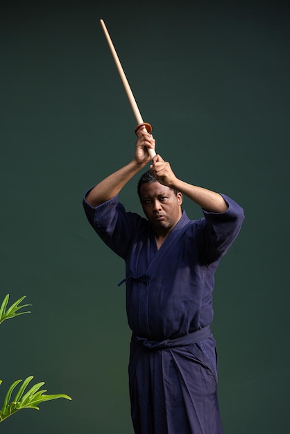 Bel homme d'artiste martial noir avec costume d'arts martiaux de kendo