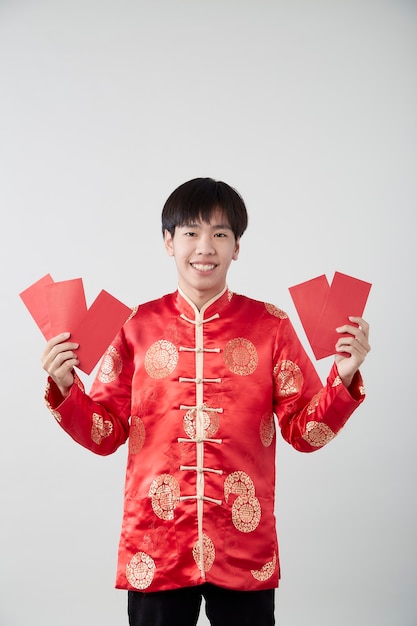 Bel homme asiatique souriant en costume oriental traditionnel isolé sur une surface gris clair pour les concepts du nouvel an chinois