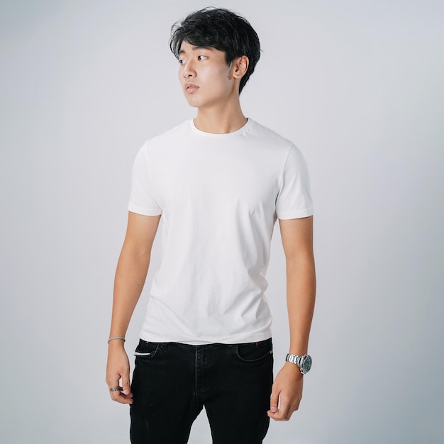 Bel homme asiatique tshirt blanc debout mur gris isolé