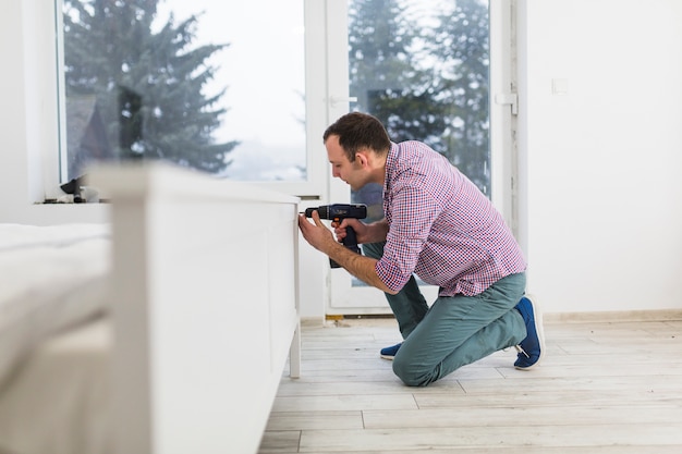 Photo bel homme assembler le lit