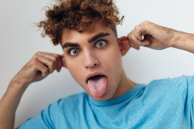 Bel homme aux cheveux bouclés dans un t-shirt bleu