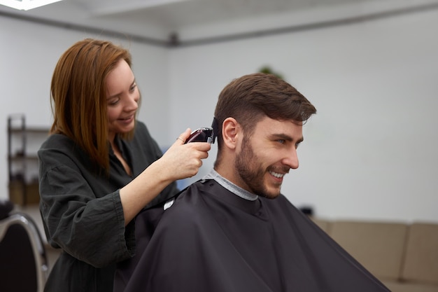 Bel homme aux yeux bleus assis dans un salon de coiffure