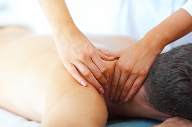 bel homme ayant un massage dans un salon spa