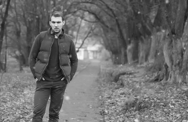 Bel homme à barbe dans le parc en automne se présentant à la caméra