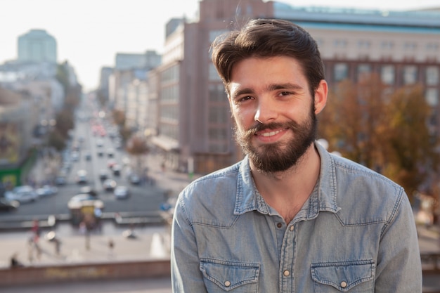 Bel homme barbu, appréciant la chaude journée à la ville