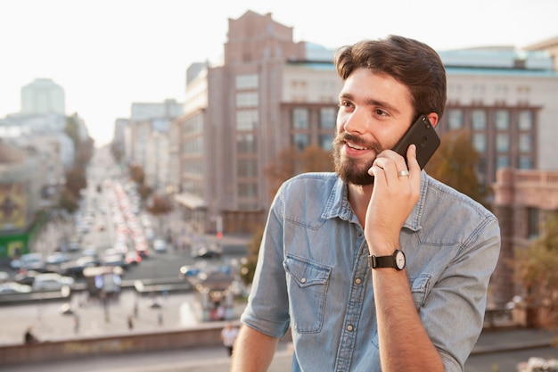 Bel homme barbu, appréciant la chaude journée à la ville