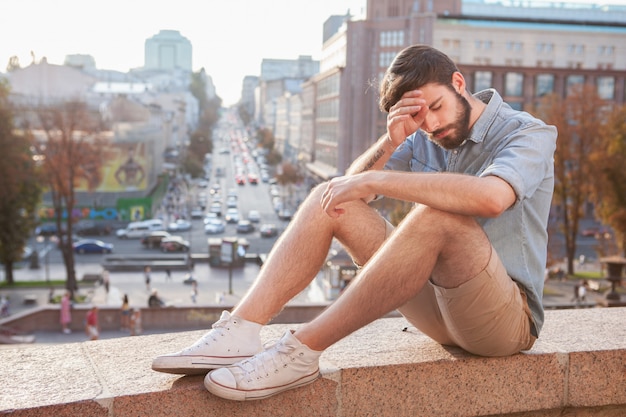 Bel homme barbu, appréciant la chaude journée à la ville