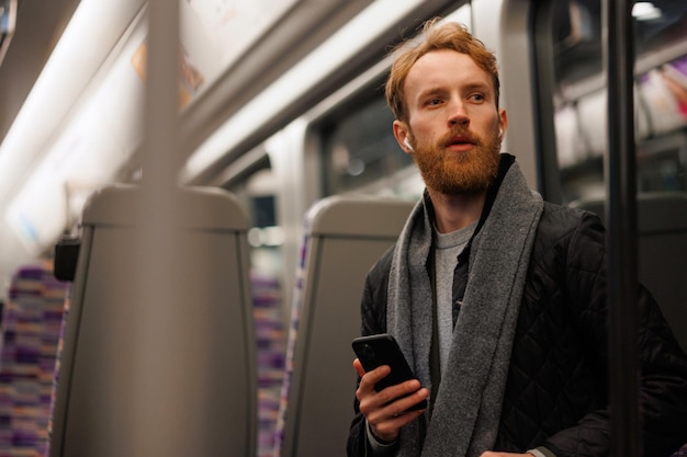 Bel homme barbu assis dans une rame de métro