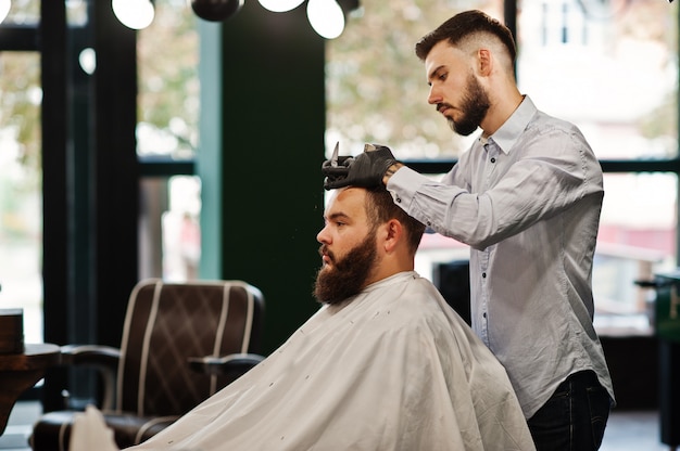 Bel homme barbu au salon de coiffure, coiffeur au travail.