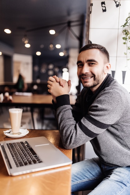 Bel Homme Barbu, Boire Du Café Tout En Travaillant Dans Un Café