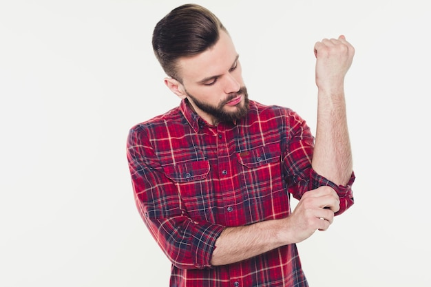 Un bel homme barbu et confiant en chemise à carreaux décontractée pose isolé sur fond blanc avec un espace de copie pour le texte et la publicité