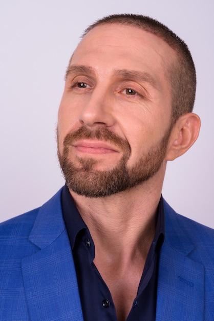 Bel homme barbu en costume avec la tête rasée à la cool sur blanc