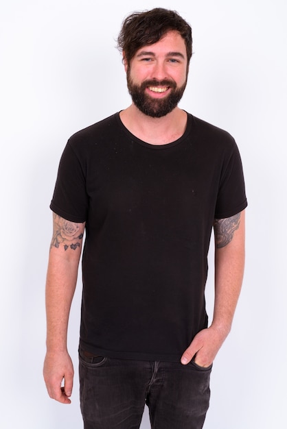 Bel homme barbu portant une chemise noire contre le mur blanc