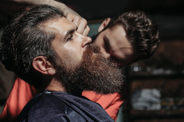 Photo bel homme barbu en salon de coiffure