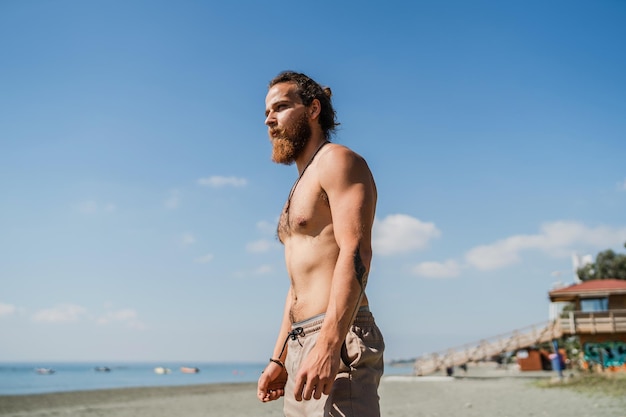 Bel homme barbu avec torse nu sur la plage