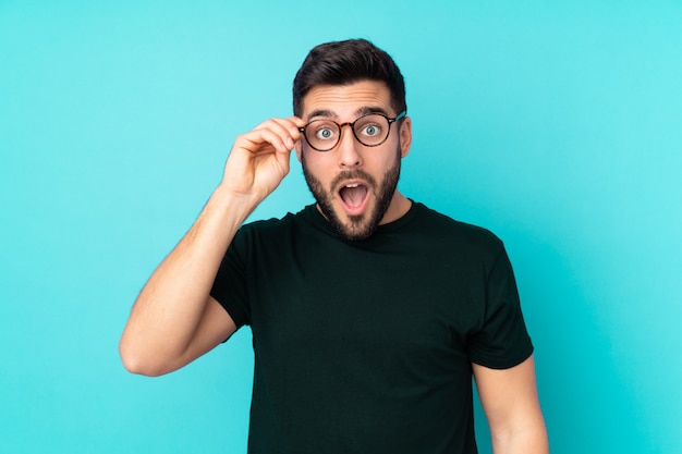 bel homme sur bleu avec des lunettes et surpris