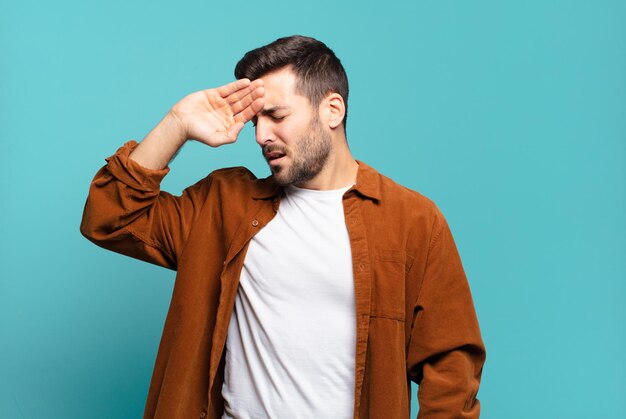 Bel homme blond adulte à l'air stressé, fatigué et frustré, séchant la sueur du front, se sentant désespéré et épuisé