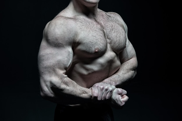 Photo bel homme bodybuilder ou mec musclé sexy avec torse de corps d'athlète et sport d'entraînement de poitrine et posant dans une salle de sport en noir et blanc