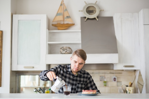 Bel homme, boire du café dans la cuisine