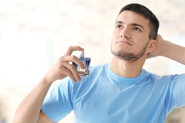 Bel homme avec une bouteille de parfum à la maison