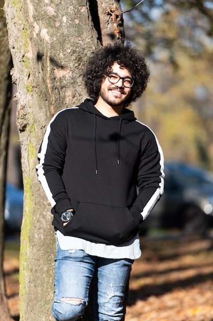 Bel homme branché posant dans le parc d'automne seul