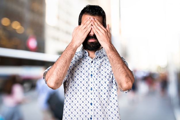 Bel homme brune avec une barbe couvrant ses yeux