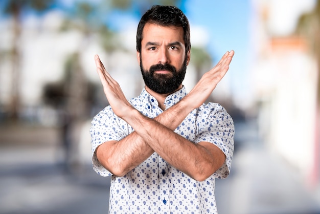 Photo bel homme brune avec une barbe ne faisant aucun geste