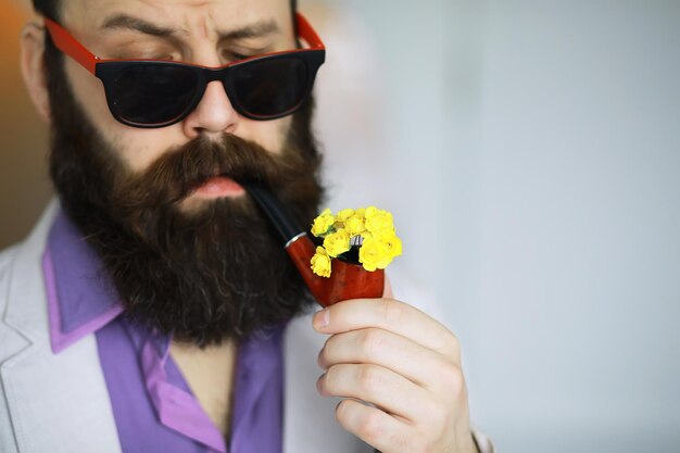 Bel homme ou bûcheron, hipster barbu, avec barbe et moustache en chemise avec pipe
