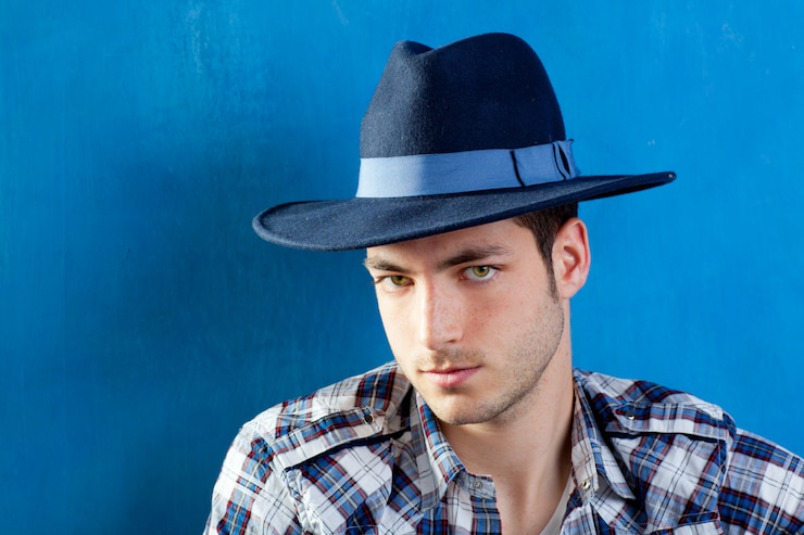 Photo bel homme avec une chemise à carreaux et un chapeau de cowboy