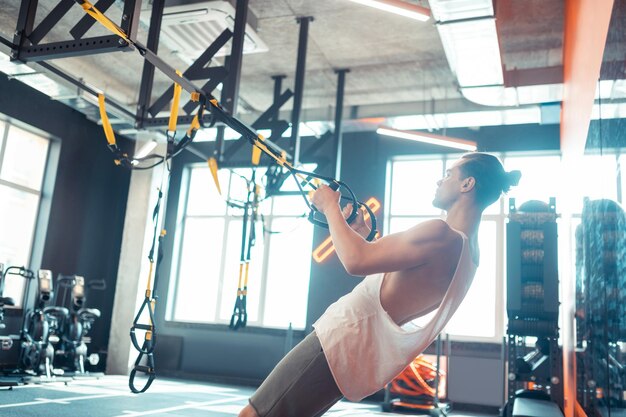 Bel homme confiant travaillant dans la salle de gym