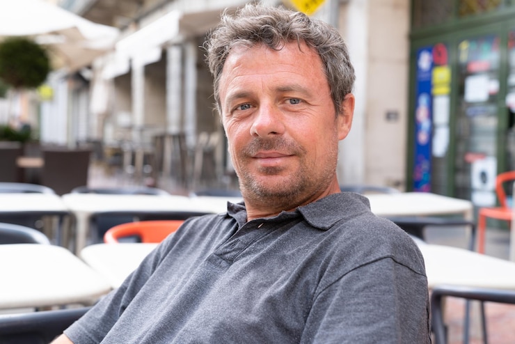 Photo bel homme cool souriant sur la terrasse du café en plein air