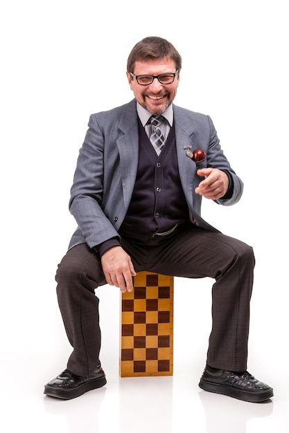 Un bel homme en costume et lunettes avec des échecs et une pipe pour fumer Fond blanc