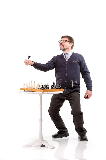 Photo un bel homme en costume et lunettes avec une pipe pour fumer et échecs fond blanc