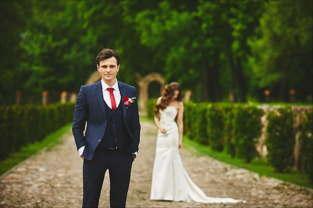 Bel homme en costume de mariée attend la rencontre avec sa mariée. Couple avant la cérémonie de mariage