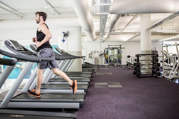 Bel homme courir sur tapis roulant