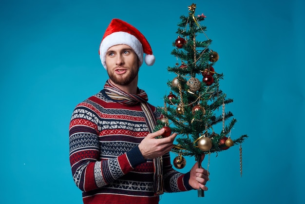 Bel homme dans un chapeau de santa tenant un fond bleu de vacances de bannière