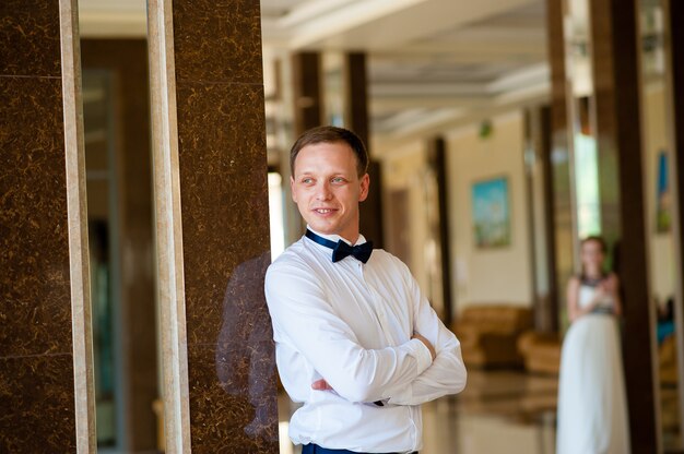 Bel homme dans une chemise blanche à l'intérieur.