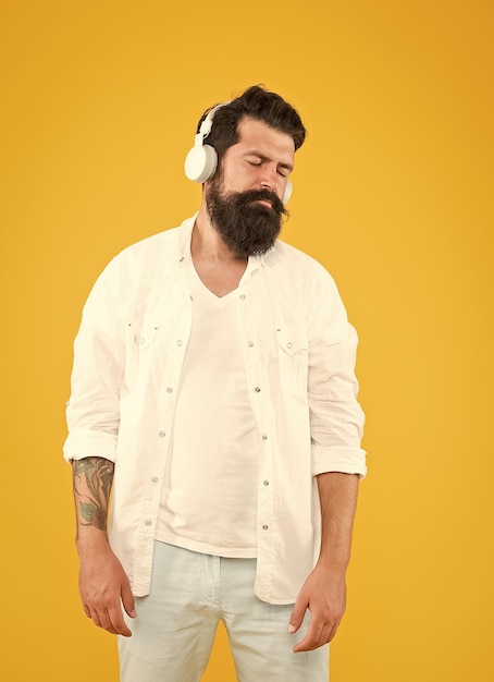 Bel homme dans les écouteurs écoutant de la musique profiter de la chanson préférée prête pour la fête hipster été mode masculine nouvelle technologie et appareil numérique accessoire moderne pour se détendre