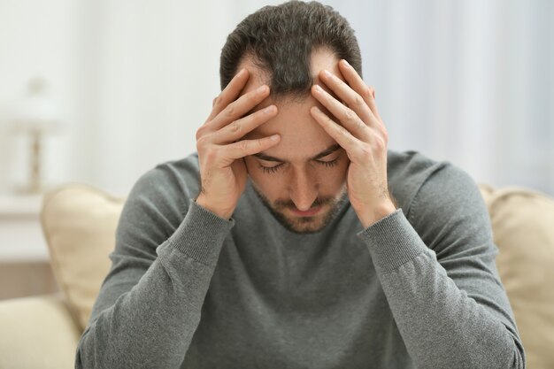 Bel homme déprimé à la maison, gros plan