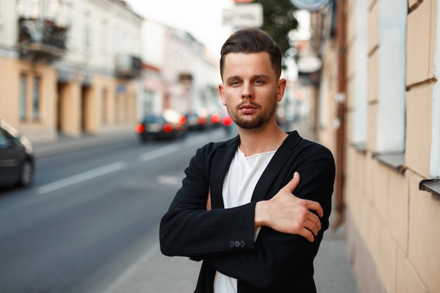 Bel homme élégant en vêtements d'affaires dans la rue le jour d'été