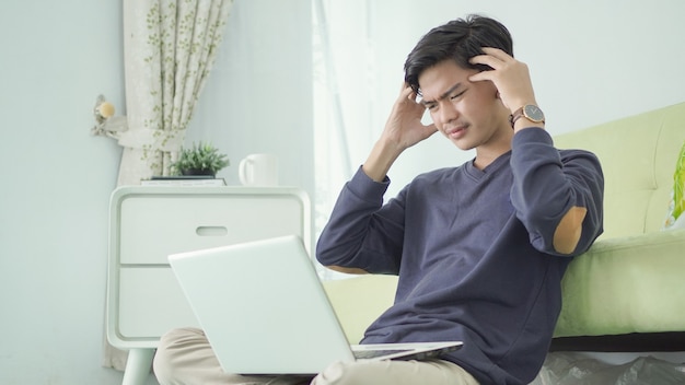 Le bel homme est stressé à cause du travail à domicile