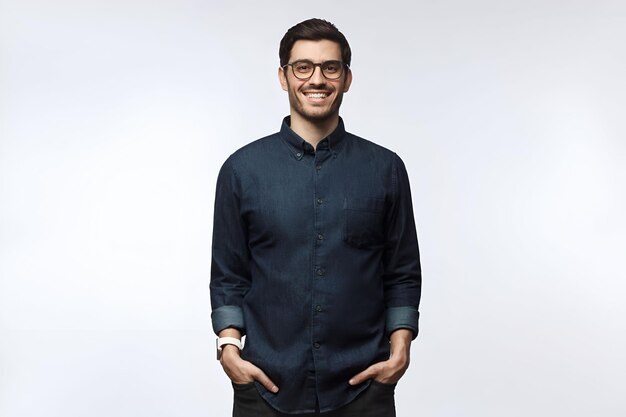 Photo un bel homme européen souriant en chemise denim décontractée debout contre le blanc