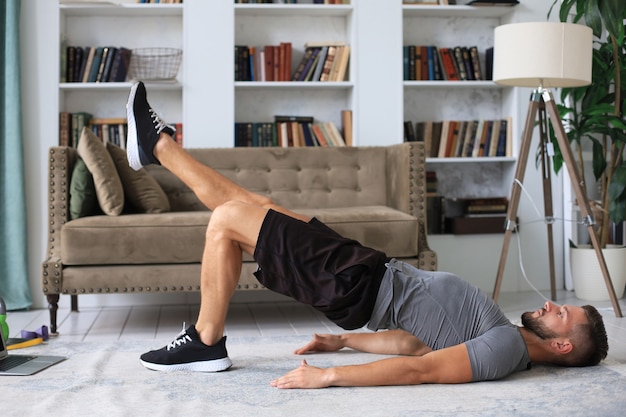 Bel homme faisant du sport à la maison pendant la quarantaine. Concept de vie saine