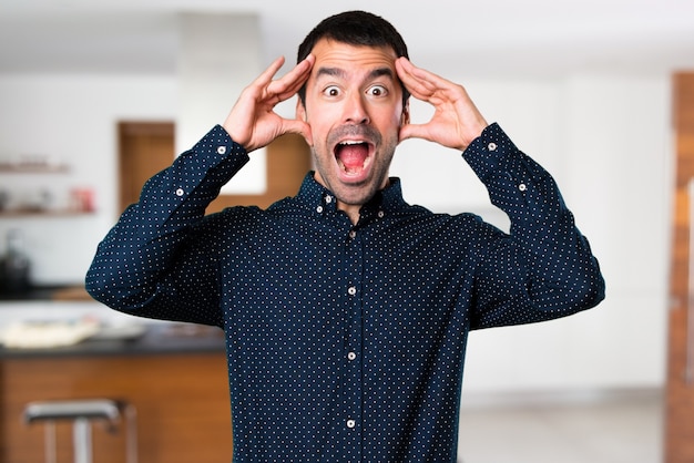 Bel homme faisant un geste surprise à l&#39;intérieur de la maison